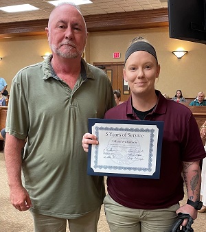 Mike Roark presents certificate to Tiffany Williamson during Commissioners Court.